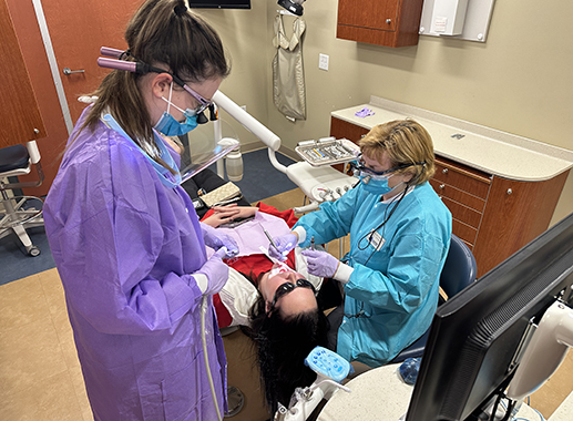 Dental students examining a patient in the dental clinic